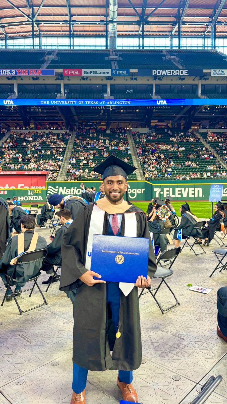 Silas Stanley Thomas at UT Arlington commencement, holding his MS in Business Analytics diploma